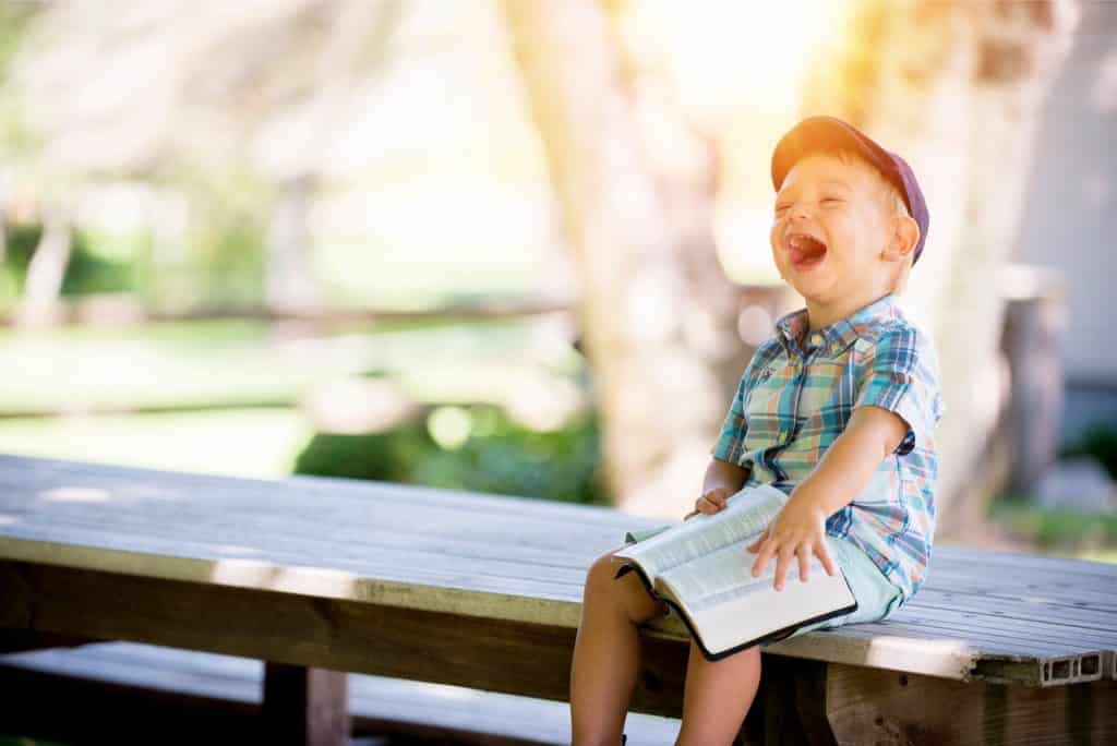 Boy laughing on a bench